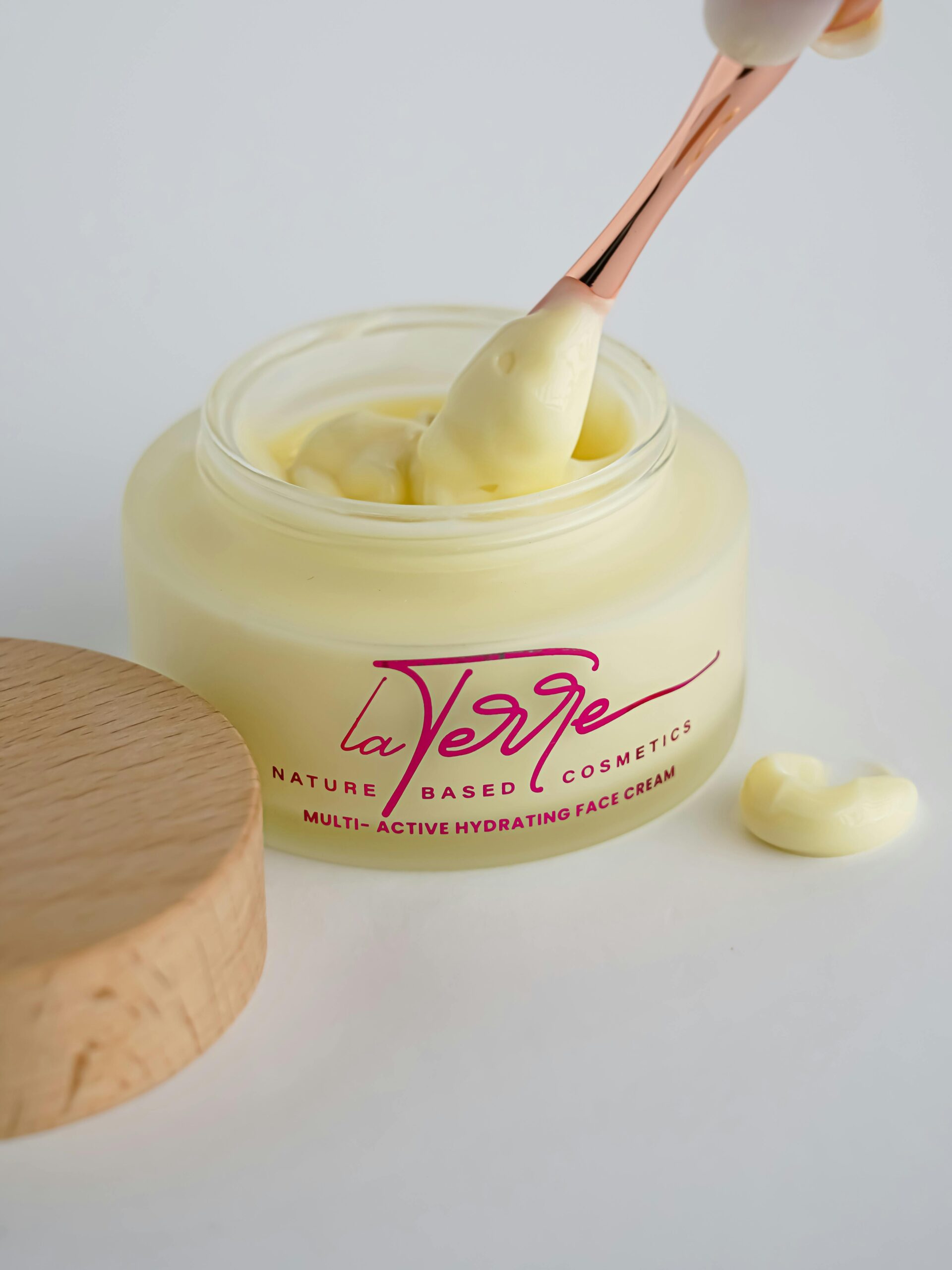 Elegant La Verge face cream with a rose gold applicator for nature-based hydration.